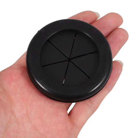 Black Rubber Grommet Kit For Cable Management With Dual Sided Buckle Design, Fire Resistant And Waterproof Desk Hole Cover For Office And Home Use, Includes Four Pieces. Black rubber cable hole cover shown in hand, round desk grommet for two cables.
