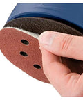Hand holding a five inch sanding disc with hook loop straps, showing eight holes for dust reduction. Get Your Hands On These 100 Pcs Of Rad Five Inch Sanding Discs With Eight Holes Hook Loop Straps For Super Smooth Drying And Heavy Duty Polishing Jobs Across Wood Metal Or Plastic Surfaces In Assorted Grit Ranging From Rough sixty Up To Ultra Fine Six.
