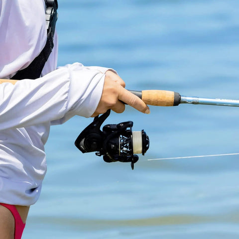 Angler holding Zephyr 1000 Spinning Reel All New Lightweight Design For Bass And Trout Fishing Ultra Smooth And Powerful Dope Performance