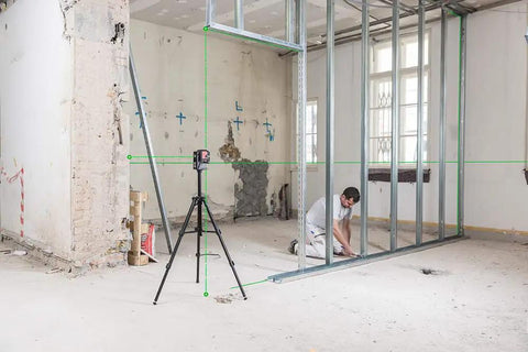 Built Tough Green Beam Cross Line Level With Razor Sharp Point Laser And Reliable Long Haul Battery Life For Fast Wall Layouts in use on job site.