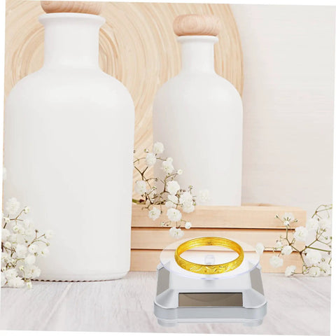 Galpada Solar Powered Jewelry Display Stand With Electric Rotating Turntable For Bracelets And Watches Plus Earrings Store Office Counter Shelf Rack Natural Light Battery Backup Smooth Spin Showcase featuring a gold bracelet on a clear display.