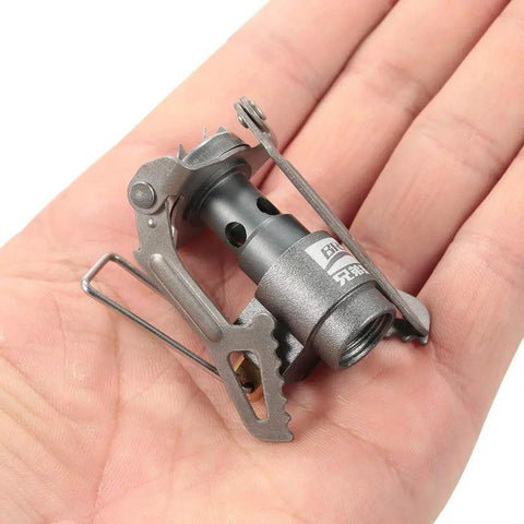 Hand holding Ultra Lightweight Titanium Gas Stove for On The Go Camping And Picnics, Portable Ultralight Burner, 2700W Cooking Power