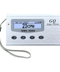 Front view of GMC-300S Geiger counter with LCD showing 23 CPM, four buttons, silver body and lanyard