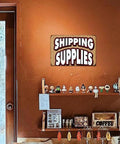 Twelve By Eight Inch Aluminum Sign For Shipping Supplies Durable Metal Wall Decor Warping And Cracking Resistant Heavy Duty Office And Warehouse Signage Perfect For Shipping Station Notices Labels And Quick Reference on brown wall