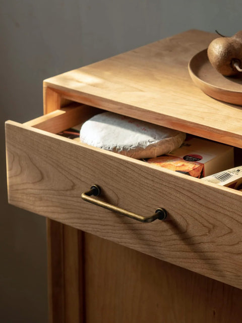 Wooden dresser with an antique brass cabinet bar pull, 3 inch center to center, showing retro style handle on the drawer front.