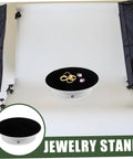 Rotating Electric Turntable Display Stand With Smooth Motorized Motion showcasing rings and jewelry on a black velvet top.