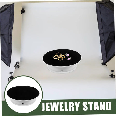 Rotating Electric Turntable Display Stand With Smooth Motorized Motion showcasing rings and jewelry on a black velvet top.