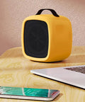 Tiny But Mighty Compact Ceramic Space Heater 500W For Home And Office Quiet Desk Heater With Overheat Protection Cozy Up Warmth Safe Yellow Portable Desk Companion For Desktop And Small Rooms on desk next to laptop