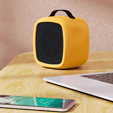 Tiny But Mighty Compact Ceramic Space Heater 500W For Home And Office Quiet Desk Heater With Overheat Protection Cozy Up Warmth Safe Yellow Portable Desk Companion For Desktop And Small Rooms on desk next to laptop