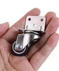 Hand holding a Four Pack 1 Inch Side Mounting Casters With TPE Swivel Plated Wheels L Shaped Mute Wheel For Baby Beds Carts Trolleys