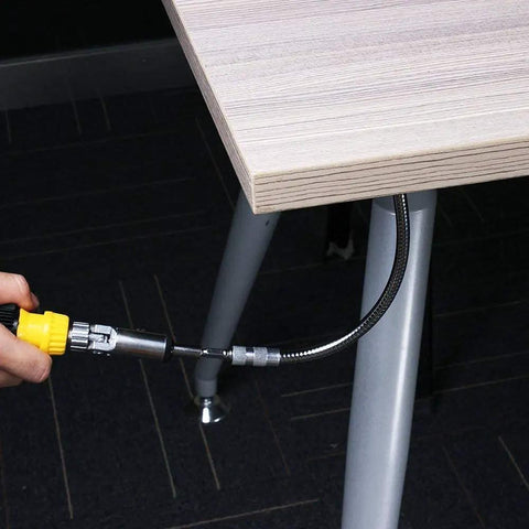 Two Piece Workhorse Flexible Extension Drill Bit Holder in use reaching a tight corner under a table, showcasing flexibility and magnetic hex shank.