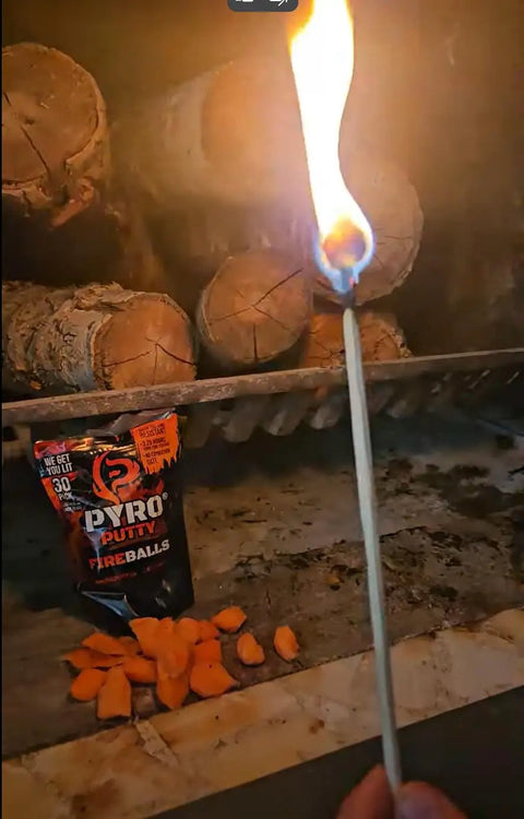 A match lighting near Fire Balls Fire Starter Pellets For Easy Fire Lighting, 7 Minute Burn Time, Waterproof And Weatherproof Emergency Kit Survival Gear, Ideal For Campin, Grillin, And Outdoor Prep, 30 Pack with logs in background.