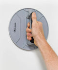 Holding the ergonomic rubber handle of the 9 Inch Radial Drywall Sander Kit With Six Assorted Grit Sandpaper Discs.