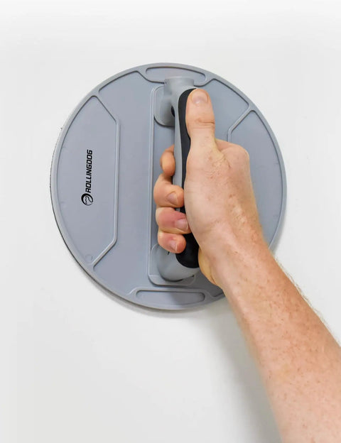 Holding the ergonomic rubber handle of the 9 Inch Radial Drywall Sander Kit With Six Assorted Grit Sandpaper Discs.