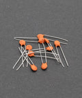 All In One Ceramic Capacitor Assortment Kit 960 Pieces 24 Values From 2pF To 0.1uF 50V Rating scattered on dark surface
