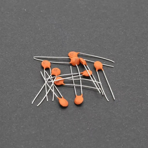 All In One Ceramic Capacitor Assortment Kit 960 Pieces 24 Values From 2pF To 0.1uF 50V Rating scattered on dark surface