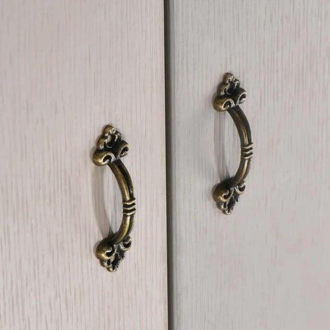 Vintage Bronze Mini Drawer Pulls Set Of 20, 1.85 Inch Antique Jewelry Box Handles on wooden cabinet doors.