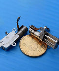 Mini 5mm Stroke Linear Actuator 2 Phase 4 Wire Stepper Motor With Precision Metal Gearbox beside a coin for size reference.