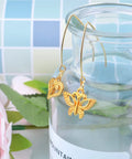 40Pcs Stainless Steel Earring Hooks Hypoallergenic V Shaped Ear Wires And 40Pcs Clear Bullet Earring Backs For DIY Dangle Earrings Jewelry Making Two Color Set Replacement Kit Must Have on display with gold butterfly and heart charms.