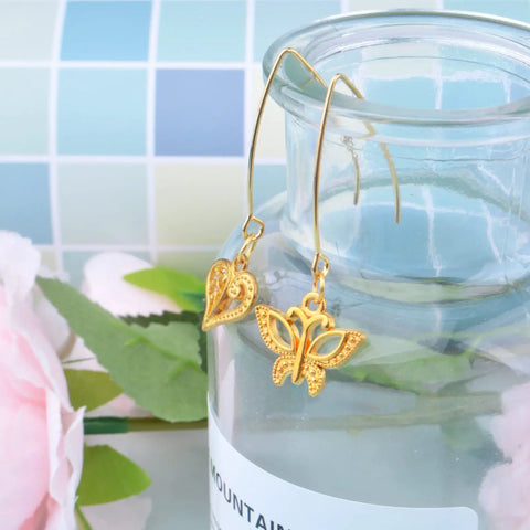 40Pcs Stainless Steel Earring Hooks Hypoallergenic V Shaped Ear Wires And 40Pcs Clear Bullet Earring Backs For DIY Dangle Earrings Jewelry Making Two Color Set Replacement Kit Must Have on display with gold butterfly and heart charms.