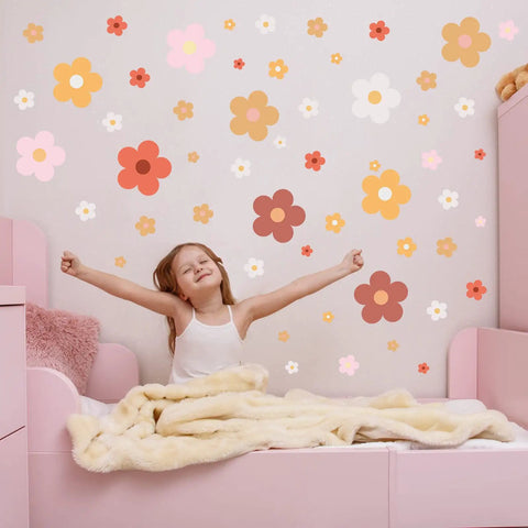 Girl in bedroom with 128 pcs colorful flower wall sticker set with groovy retro hippie vibe boho daisy decals in three sizes on wall