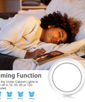 Person sleeping next to Puck Lights With Remote Control For Under Cabinet And Counter Lighting, timer settings visible.