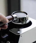 Slick Automatic Coffee Portafilter Cleaner And Espresso Grounds Knock Box Station Featuring Smart Optical Guard in use with portafilter.