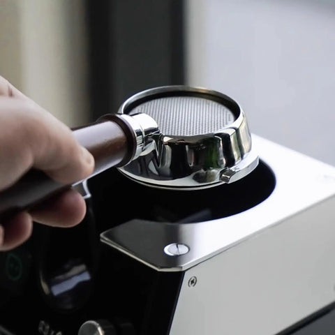 Slick Automatic Coffee Portafilter Cleaner And Espresso Grounds Knock Box Station Featuring Smart Optical Guard in use with portafilter.