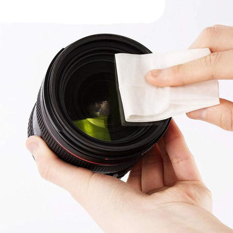 Lens cleaning paper, 4x3 inch lint-free tissue used to wipe a camera lens.
