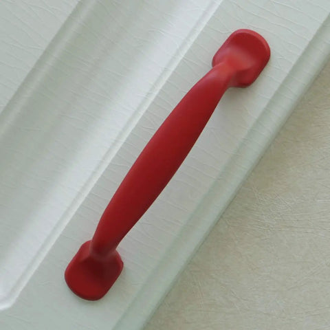 Hella Durable Zinc Alloy Drawer Knobs And Kitchen Cabinet Handles Built Tough For Daily Use Featuring Easy Grip Pulls For Dressers And Kids Furniture Hardware In Totally Dope Colors, red handle on a white surface.