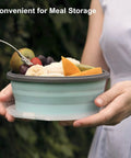 Woman holding Collapsible Silicone Camping Bowl With Airtight Lid 1200ml, filled with fruit, stainless steel fork included