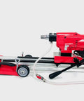 Straight Shooting Heavy Duty Workhorse Diamond Coring Drill With Tilting Rolling Base And Killer 12 Piece Wet Core Bit Set Pro Concrete Cutting Setup 110 Volt with red and silver colors.
