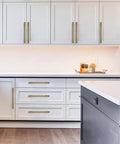 Modern kitchen with 2 Pack 4 Inch Solid Zinc Alloy Kitchen Cabinet Handles in Brushed Gold Satin Brass Finish on white cupboards.