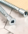 Close-up of M7x70mm hex socket countersunk self tapping furniture screws, flat head, carbon steel, zinc plated on marble surface.