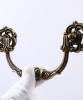 Gloved hand holding Six Pack Drop Bail Vintage Drawer Pulls for Four And A Half Inch Center To Center Spacing Zinc Alloy Handles