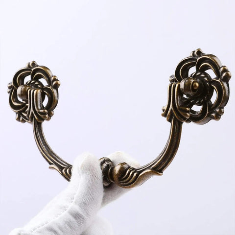 Gloved hand holding Six Pack Drop Bail Vintage Drawer Pulls for Four And A Half Inch Center To Center Spacing Zinc Alloy Handles