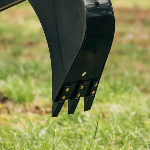 Close-up of Fronthoe Excavator Attachment For Skid Steer, 6 Ft Reach, steel teeth, used for trenching on farms, grass background