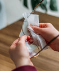 VOISEN lens wipes for eyeglasses being used on metal-frame glasses; pre-moistened wipe.