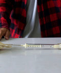 Man using 0.5mm Wire Diameter Compression Springs Set 6mm Outer Diameter 15mm Length for measuring force with a spring scale