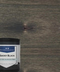 Premium Ebony Black Oil Based Wood Stain against a textured wood background, featuring a rich matte finish.