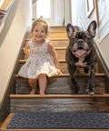 Child and dog on wooden stairs with 6 Piece 8.5 Inch By 30 Inch Non Slip Stair Treads For Wooden Steps Traction For Elders And Pets