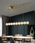 Modern Minimalist Nine Light Brass Pendant Light With Sleek Magic Bean Profile delivering lowkey stunning vibes over a dining table.