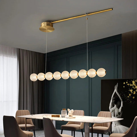 Modern Minimalist 9 Light Brass Magnetic Bean Pendant Lamp Sculptural Chandelier hanging over a dining table in a cafe decor.