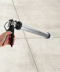 Heavy Duty Metal Caulk Applicator With Thick Steel Rod For Concrete Seams And Tile Grout Lines Smooth Squeeze Sealant Gun in hand.