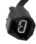 Close-up view of a black automotive two-pin electrical connector for a power brake booster vacuum pump, white insert visible