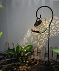 Solar Garden LED Light Watering Can Fairy Lights for Pathway Yard Lawn Patio Decor Outdoor Stake Light illuminated at night.