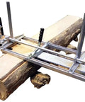 Portable Chainsaw Mill 36 Inch With 9 Foot Rail Guide System for log milling, aluminum frame attached to tree trunk on site.