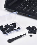 Ultimate USB Port Dust Plug Kit With 30 Silicone Caps and brush next to a laptop, showcasing USB, Micro USB, and iPhone port covers.
