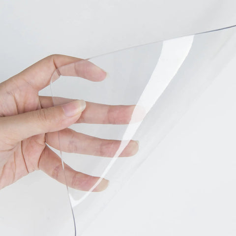 Close-up of hand holding a Clear PVC Desk Pad For Writing 23.6x13.7 Inches, Heat Resistant Waterproof Oil Proof Anti Static Desk Protector