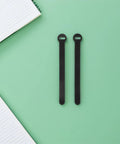 Super Solid 100 Piece Pack Of Self Adhesive Nylon Cable Ties With Cute Round Heads on a mint green surface next to a notepad.